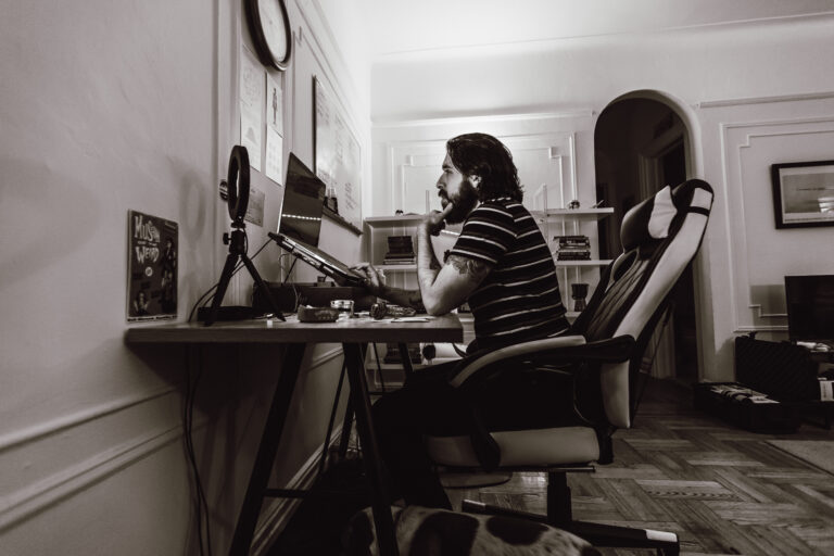 Andrew Ward seated at a desk, refining cannabis SEO, cannabis SEO services, and content marketing strategies in a black-and-white home office scene.