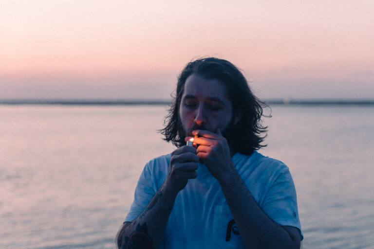 Andrew Ward lighting a joint at sunset, illustrating his passion for the plant, cannabis copywriting and content marketing services