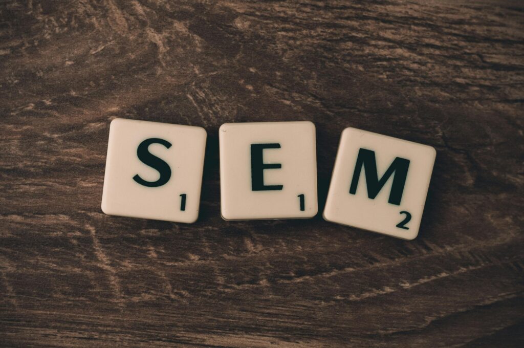 Scrabble tiles spelling out SEM on a wooden surface, symbolizing cannabis search engine marketing.